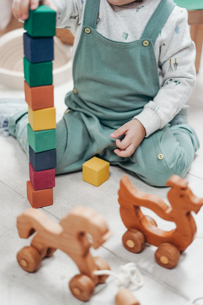 why-choose-us-01 A child enjoying playtime indoors with colorful wooden blocks and toys.